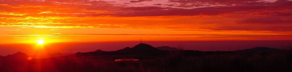 Radio mast silhouetted on a ridge at sunrise