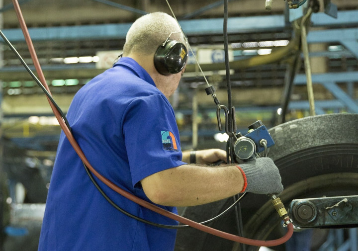 A plant worker in hearing protection on a production floor