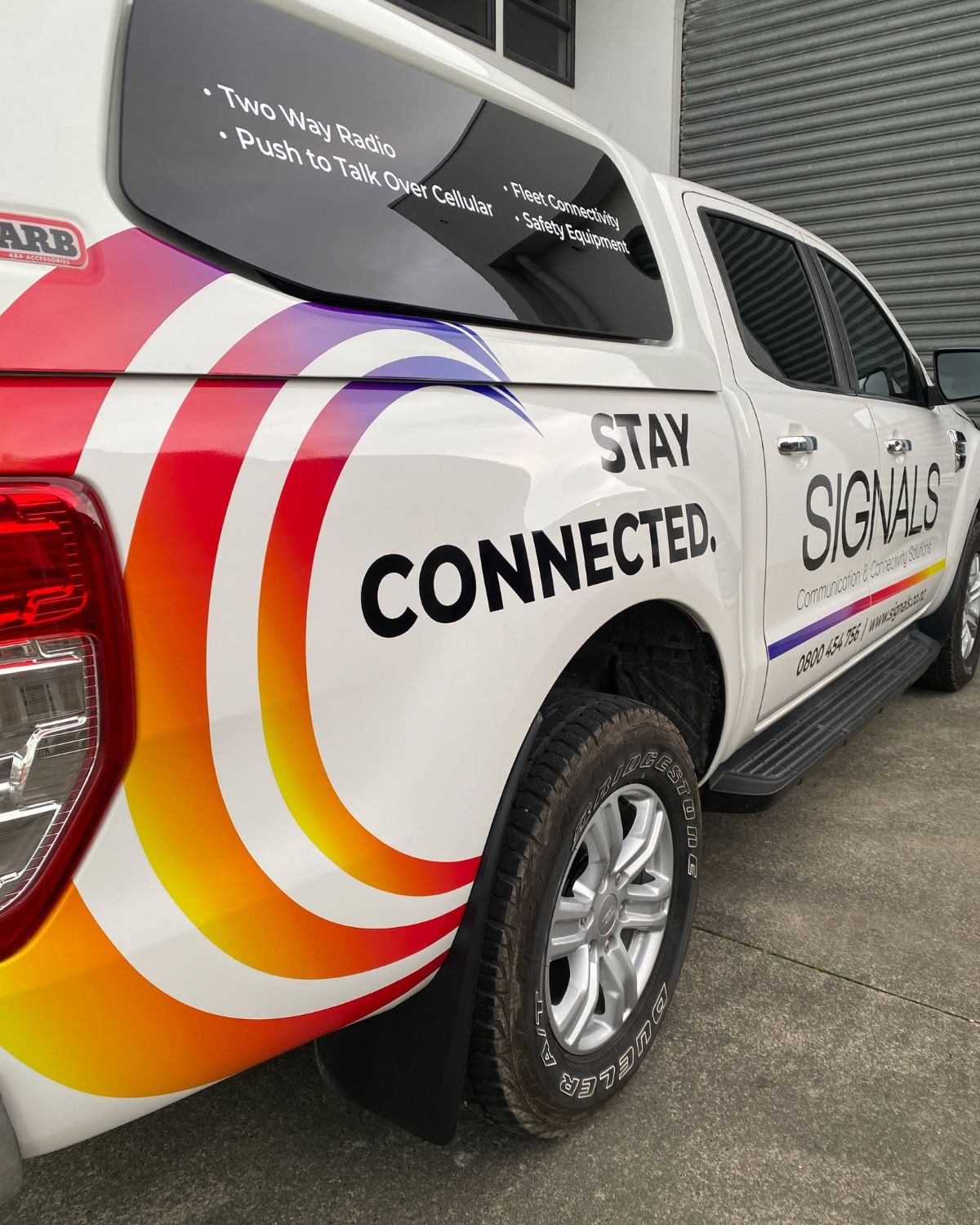 Signals NZ service ute, signwritten &lsquo;Stay connected&rsquo; with two-way radio and push-to-talk over cellular listed on the canopy